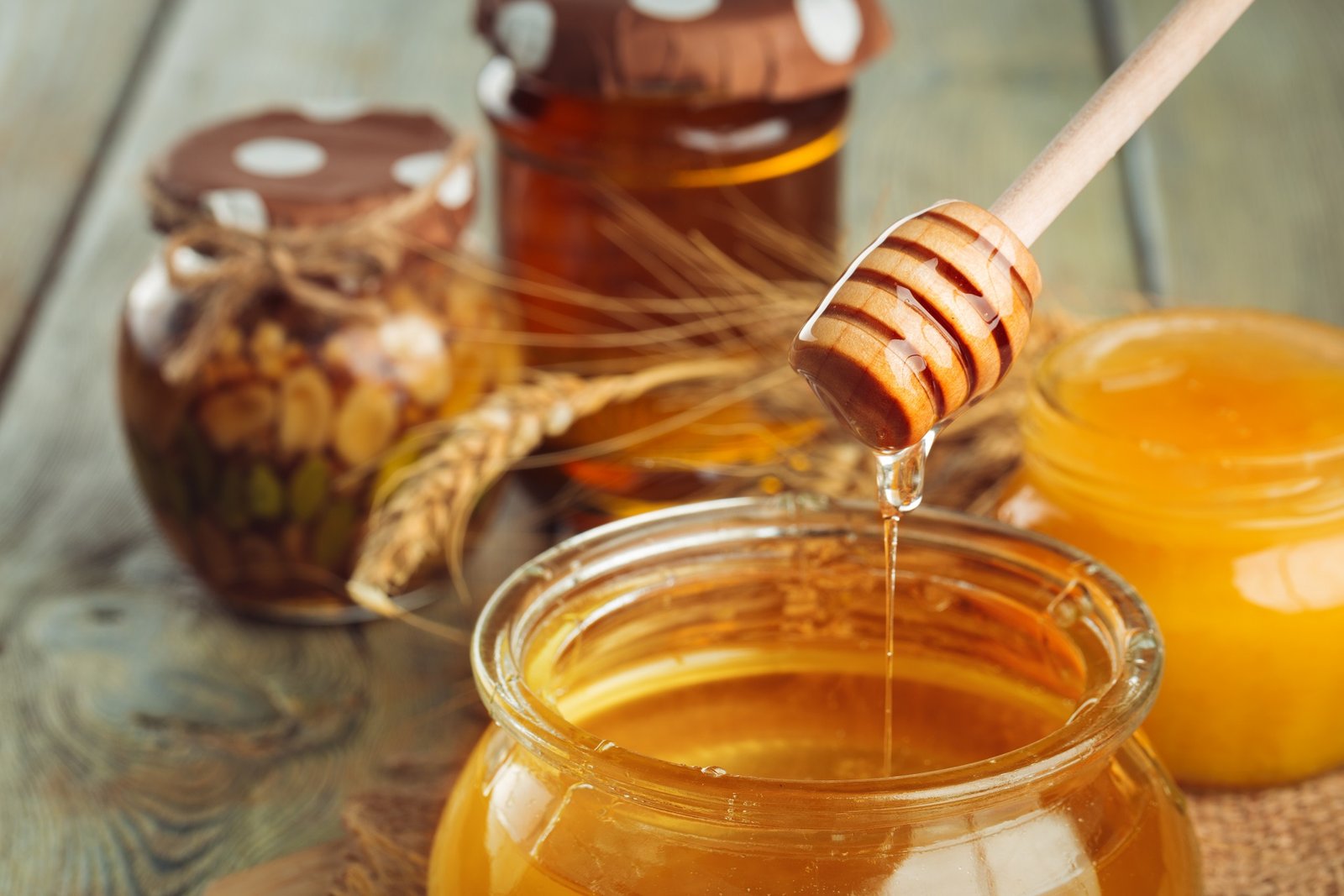 Honey background. Sweet honey in glass jar on wooden background. creative photo.